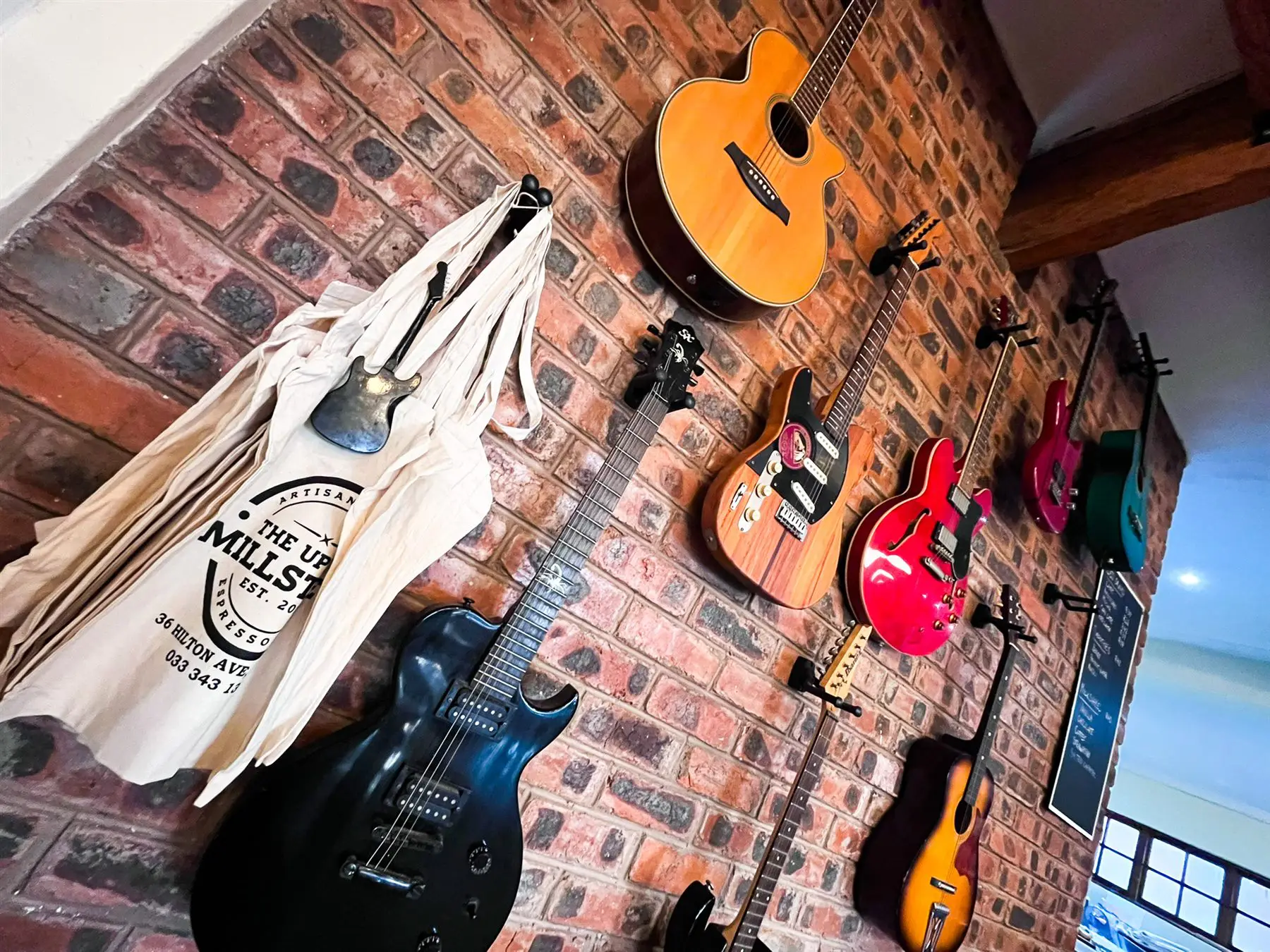 Wall of guitars at The Upper Millstone — Hilton artisan bakery and espresso bar
