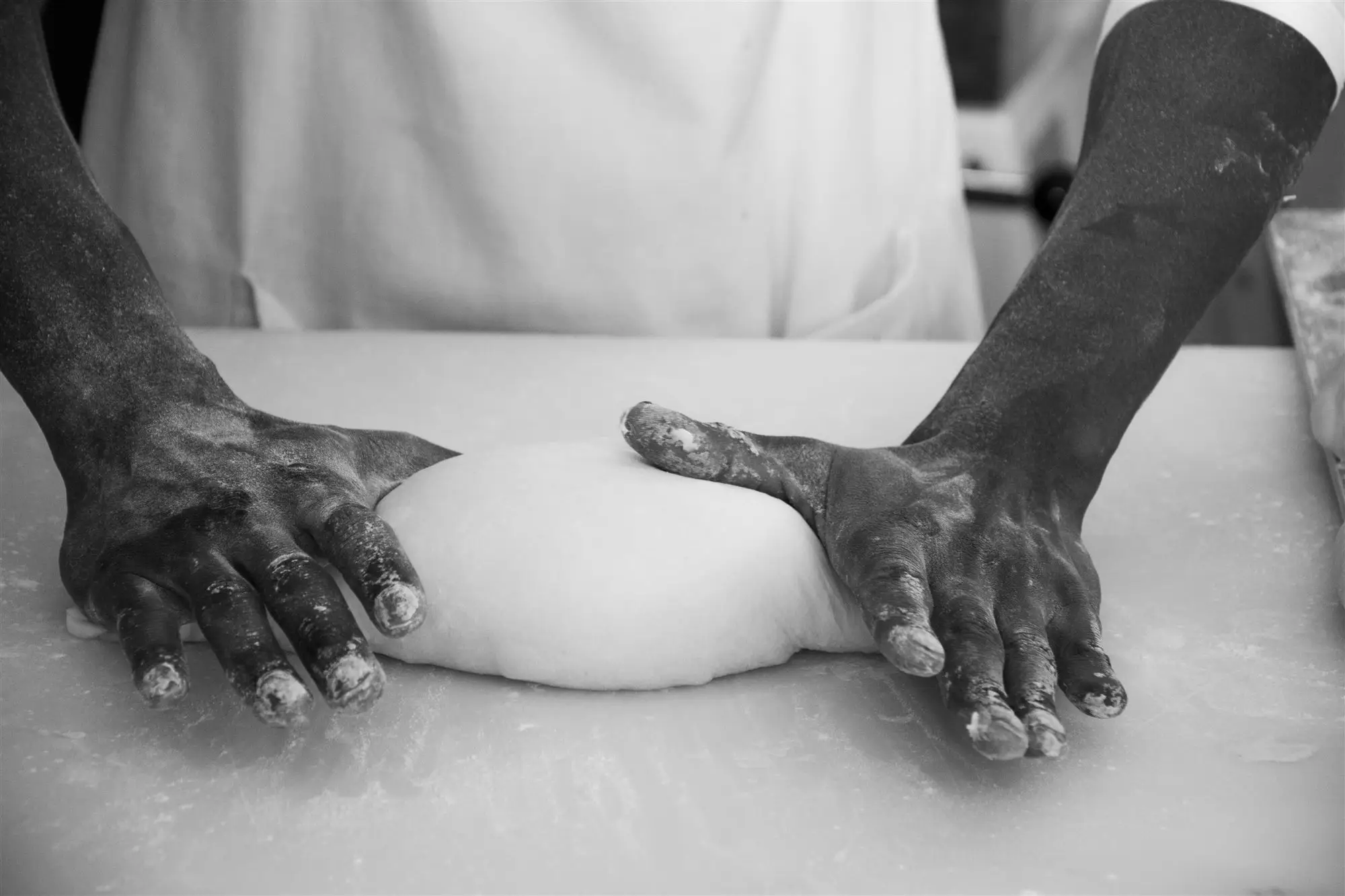Baker's hands shaping sourdough by hand at The Upper Millstone