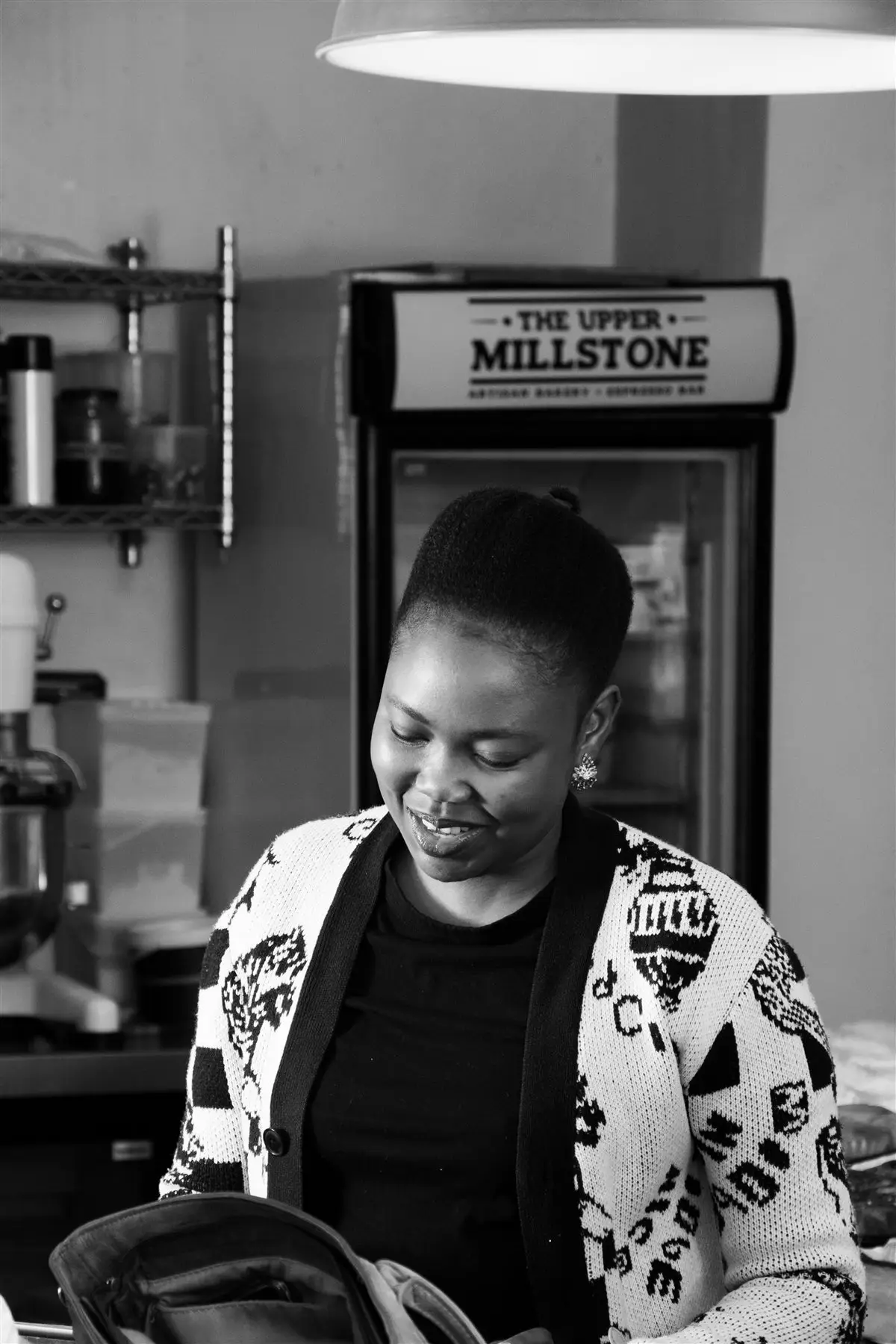 A member of The Upper Millstone team behind the counter